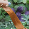 Antitheft Jacquard Strap in brown-gold, demonstration of flexibility 