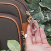 Anti-theft water resistant Crissy Full Crossbody. Demonstration of zipper pull clasp used  to secure bag closed and deter pickpockets
