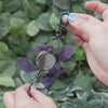 Phone tether in black-gunmetal, pulling it extends the retractable steel cable tether