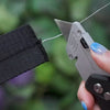 Anti-theft jacquard strap in black. Demonstration of built in steel cable with a box cutter